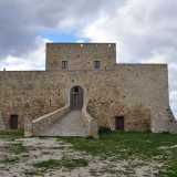 ...preceduta da ingresso in salita che porta davanti un arco protetto da un cancello in ferro
